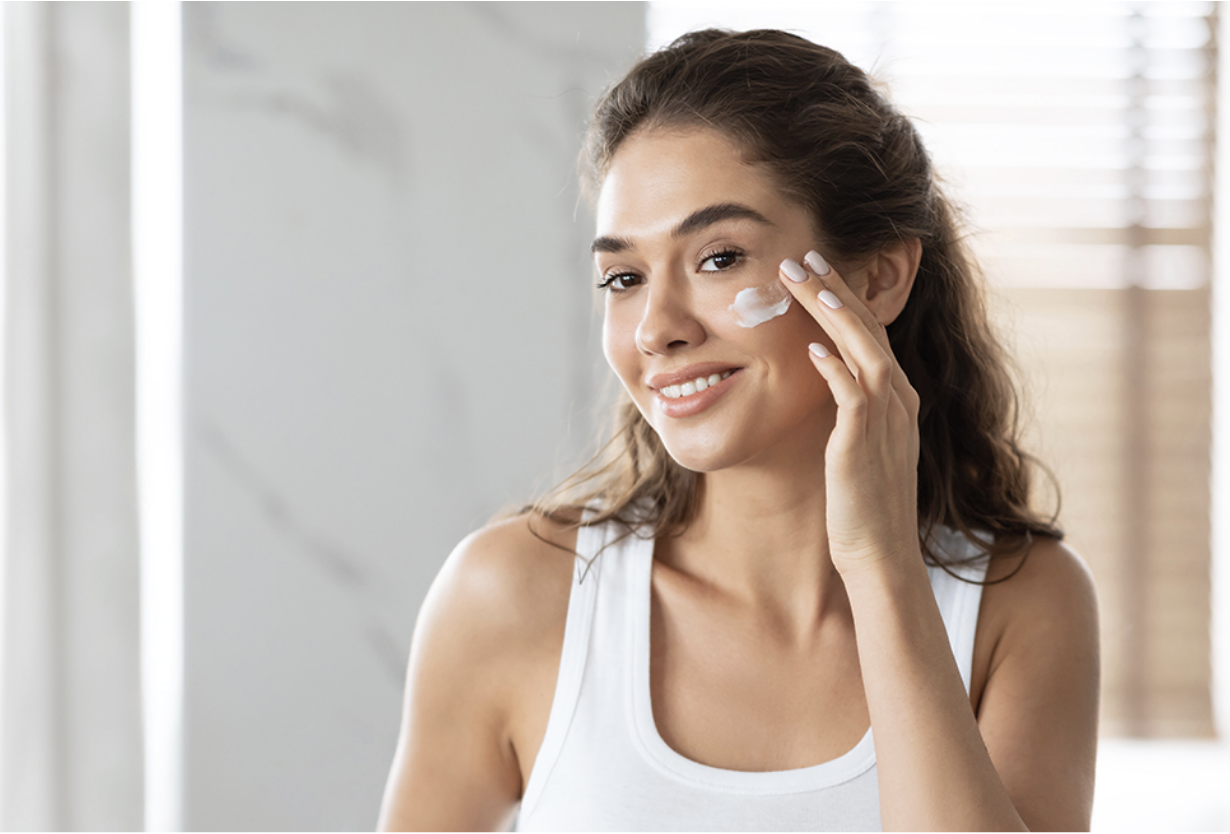 A Boca Raton woman applying cream to her face as part of her daily skin care routine