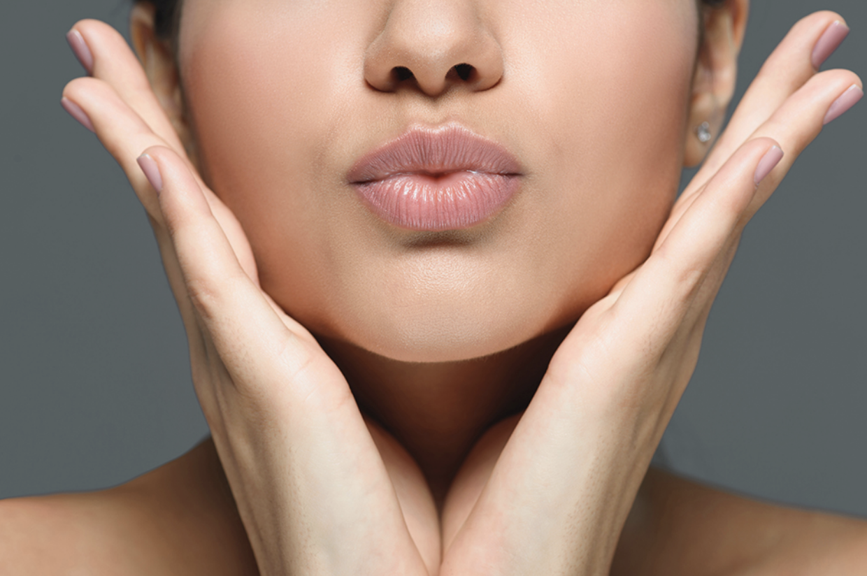Partial view of a woman with her hands at her cheeks and pursing her lips