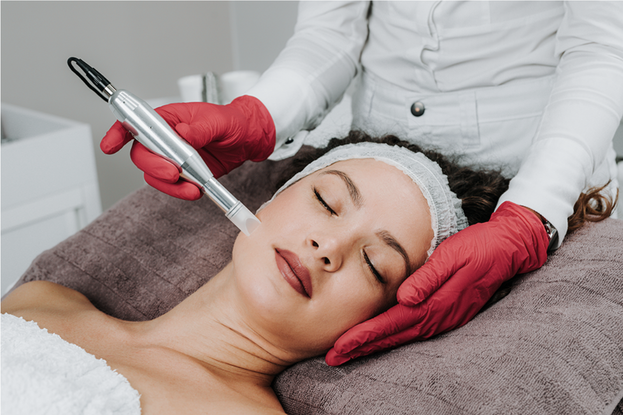 A woman seated on a medical chair receiving a PRP vampire facial treatment at Frieder Dermatology in Boca Raton