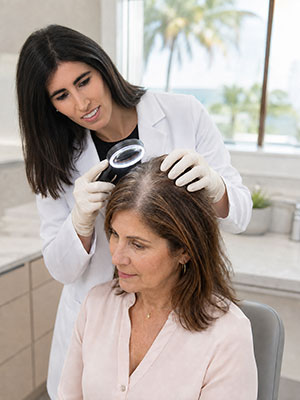 Dr. Jillian Frieder examines a woman’s widening hair part and perimenopause-related hair thinning.